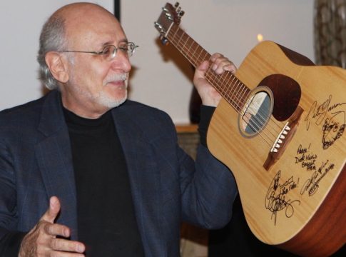 Peter Yarrow holding a guitar autographed by Peter, Paul & Mary that we auctioned off for thousands of dollars to help support Orphans International Worldwide at a benefit in Peter's NYC home. Photo credit: John Lee / The Stewardship Report.