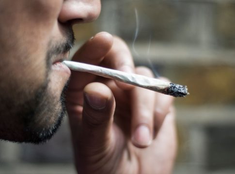 B3AN1K Close-up of an Asian man smoking marijuana joint