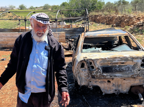 
Palestinian man stand by a car and a greenhouse torched by Israeli settlers in Sinjil. Photo credit: MEE/Mohammed Turkman​​​​.