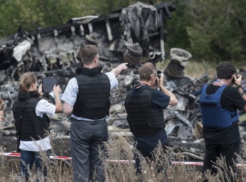 Members of the Organization for Security and Cooperation in Europe (OSCE) Special Monitoring Mission to Ukraine examine the MH17 crash site in July 2014. Photo credit: OSCE/Evgeniy Maloletka.