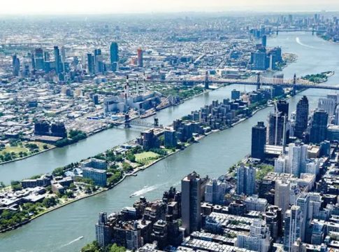Aerial view of Roosevelt Island in New York City, nestled under the 59th Street Bridge between Manhattan and Queens; it is part of New York County considered "Manhattan."