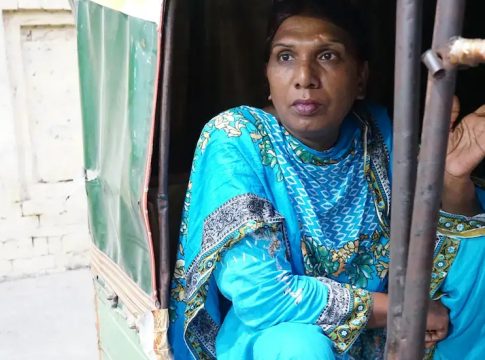 Ashi Jaan, age 45, takes a break from the protest to sit and smoke a cigarette while chatting with the rickshaw driver. Pakistan, 2016. Photo credit: Ikra Javed. 